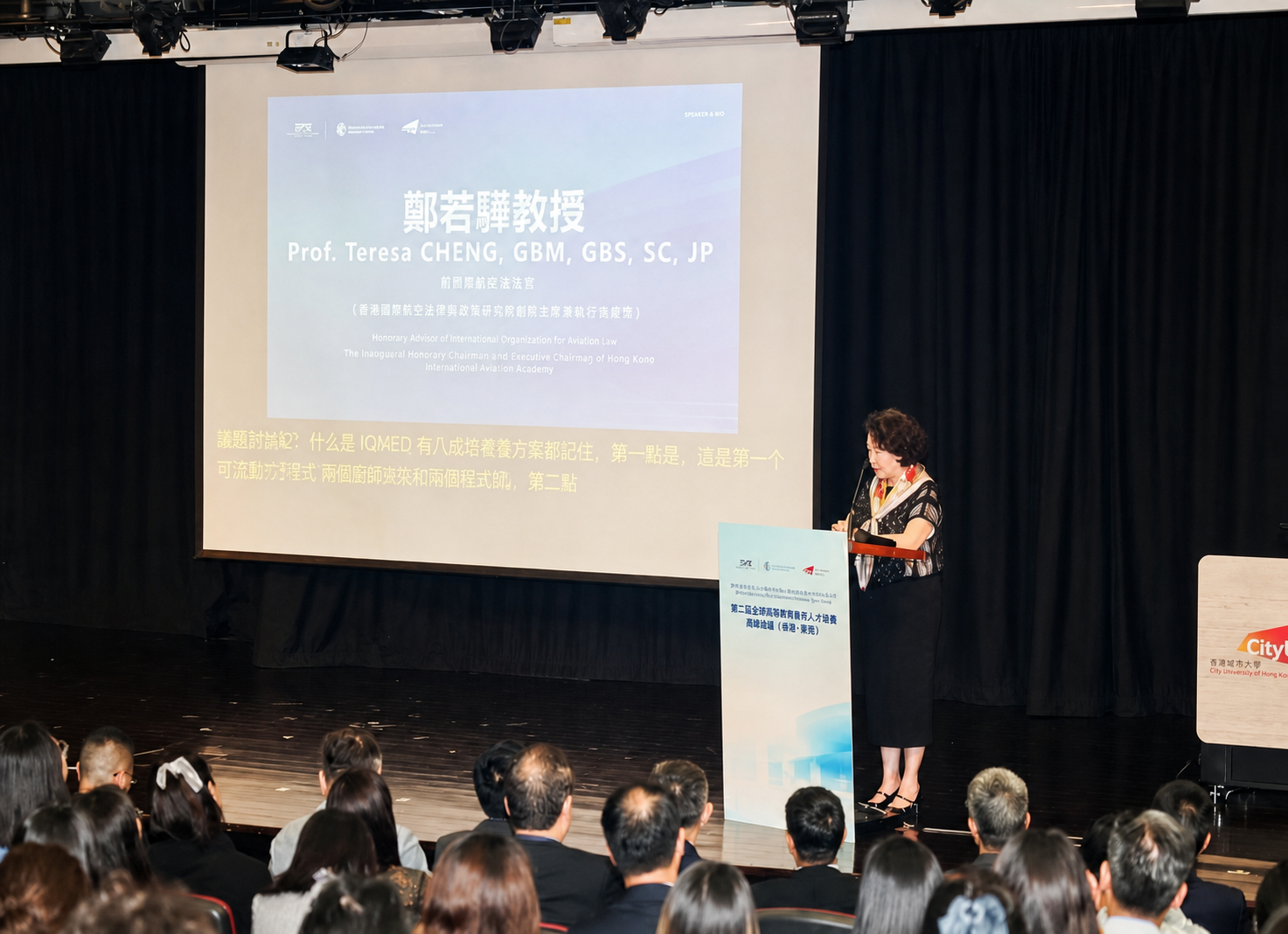 A woman speaker addresses the audience from the podium at the Hong Kong Summit Forum.