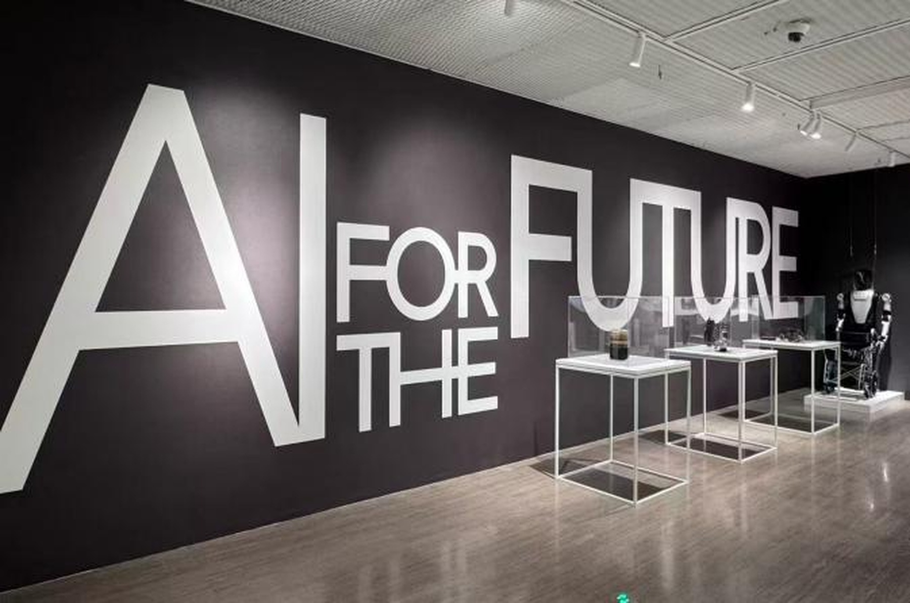 The AI FOR THE FUTURE flagship exhibition entrance and installation at the 2026 World Artificial Intelligence Conference in Shanghai, featuring minimalist vitrines and robotic technology.